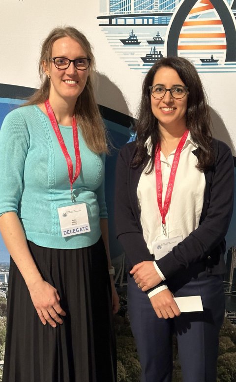 Kristi Krebs and Lili Milani are standing next to each other at a medical genomic congress