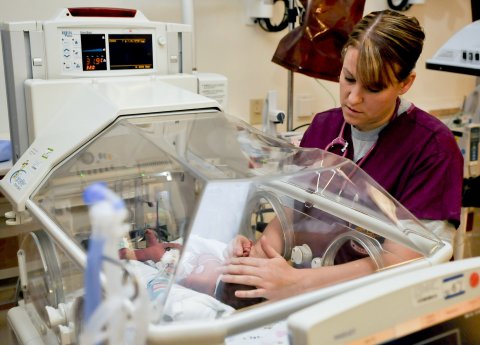 nurse taking care of a baby in an incubator
